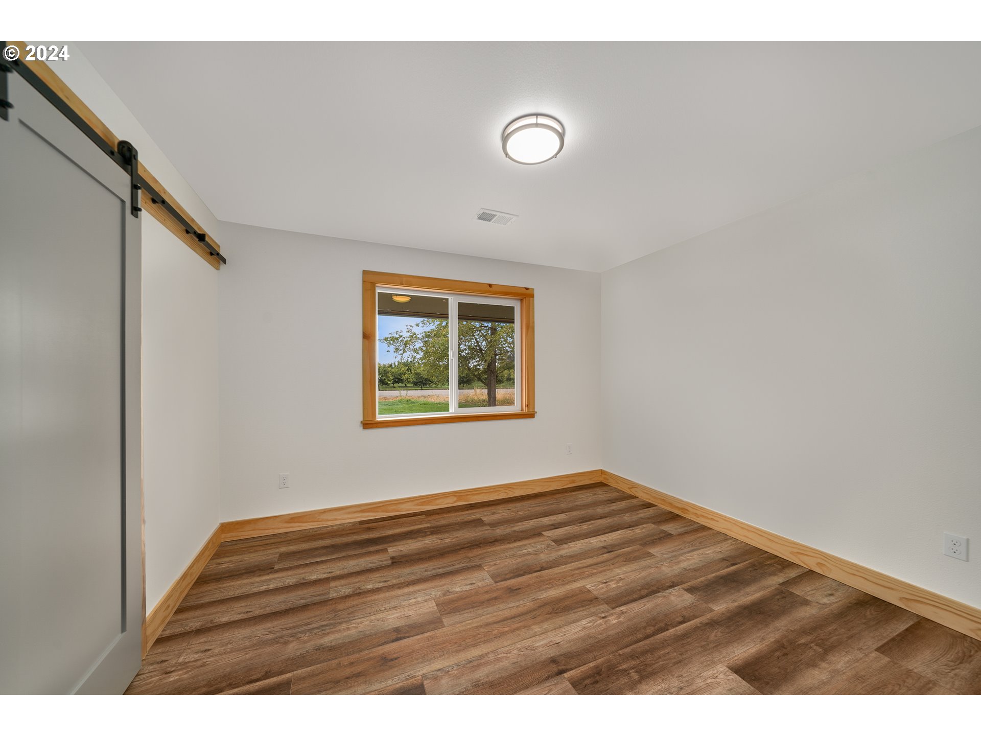 10271 Shaff Road Southeast Aumsville, OR 97325 - Photo 21 of 32 a view of an empty room with wooden floor and a window