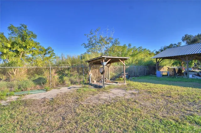 a backyard of a house with table and chairs