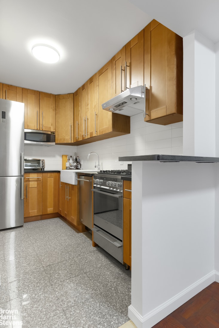 340 East 74th Street, Unit 1J Manhattan, NY 10021 - Photo 3 of 6 a kitchen with stainless steel appliances granite countertop a stove a sink and a refrigerator