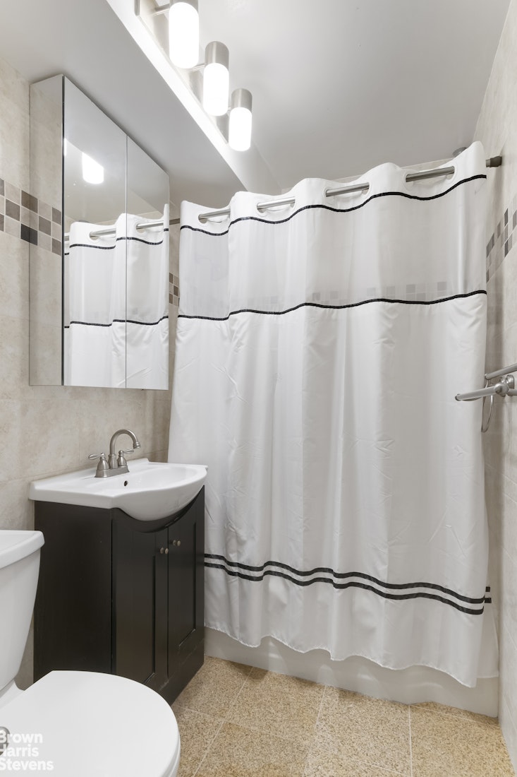 340 East 74th Street, Unit 1J Manhattan, NY 10021 - Photo 5 of 6 a bathroom with a sink a toilet and shower