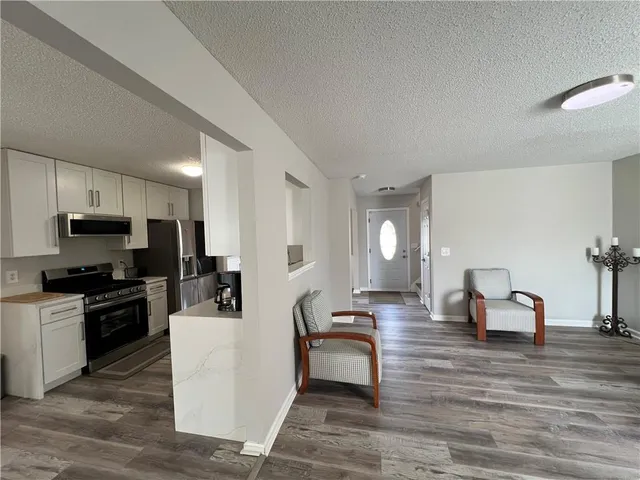 a living room with furniture a dining table and kitchen view