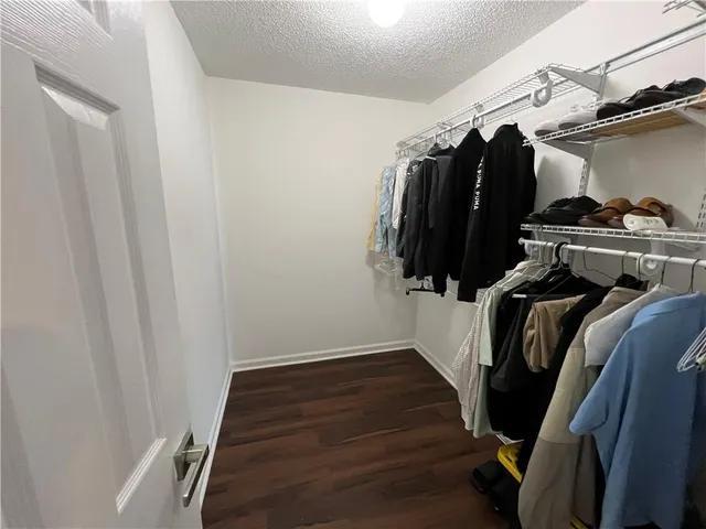 a view of walk in closet with clothes and shoes