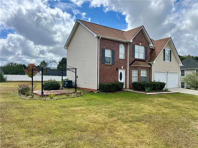 a view of a house with swimming pool and a yard