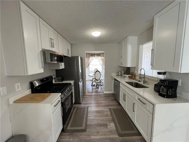 a kitchen with a sink stove and cabinets