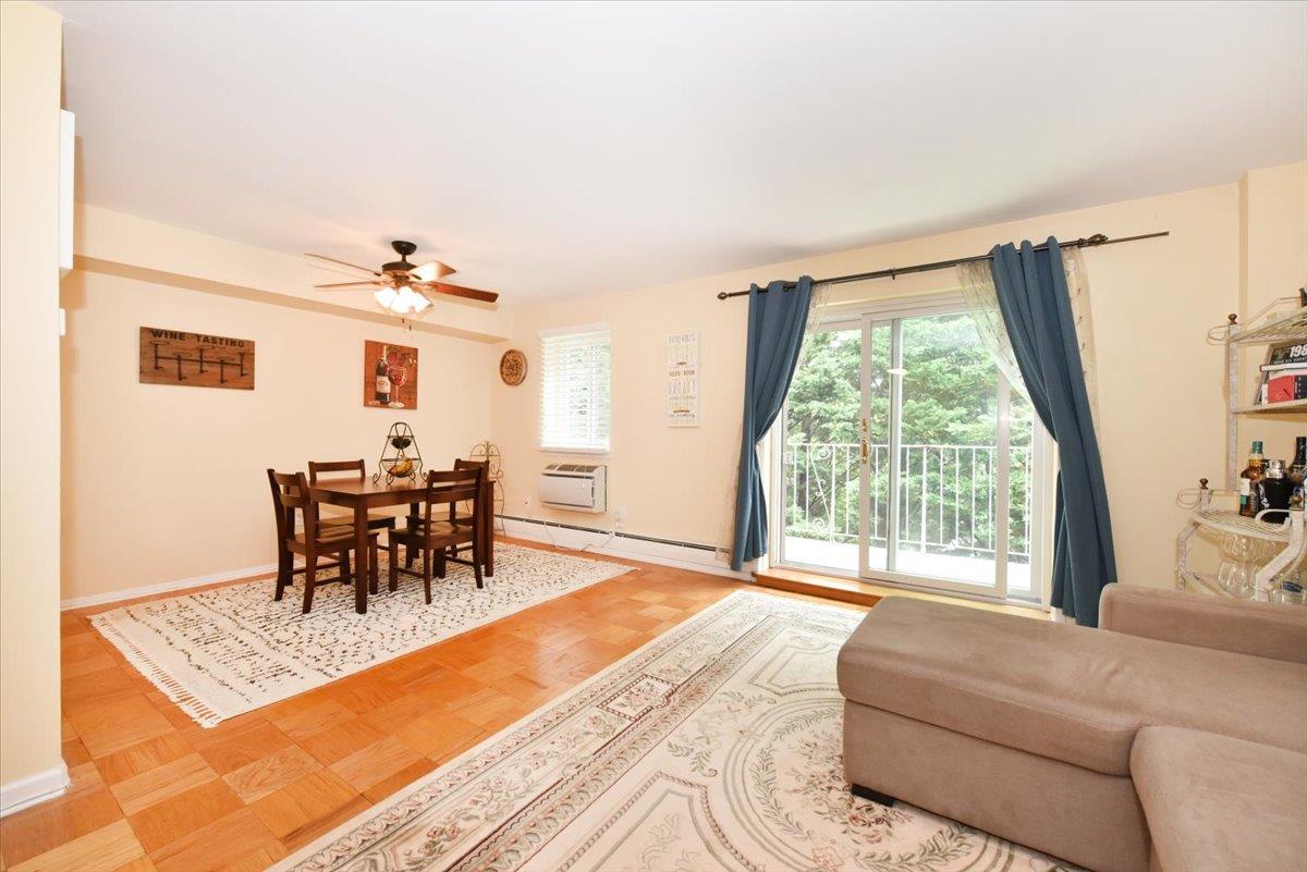 320 East Shore Road, Unit 10C Great Neck, NY 11023 - Photo 14 of 30 Dining space featuring a ceiling fan, a baseboard heating unit, and an AC wall unit