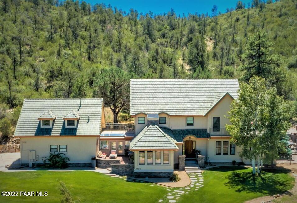 a aerial view of a house next to a big yard and large trees