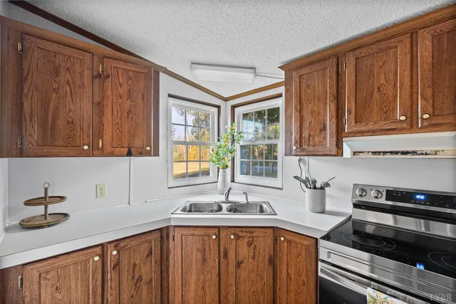a kitchen with stainless steel appliances granite countertop a sink dishwasher stove and cabinets