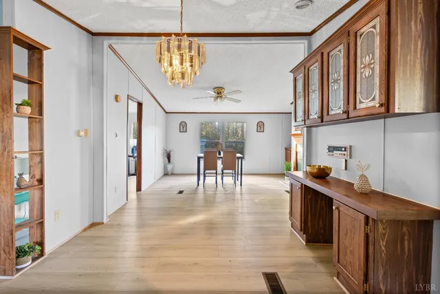 a open kitchen with stainless steel appliances granite countertop a refrigerator a sink dishwasher a dining table and chairs with wooden floor