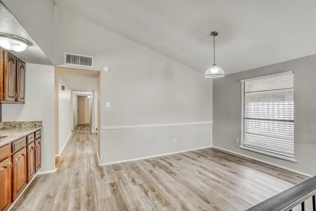 a kitchen with a refrigerator and wooden cabinets