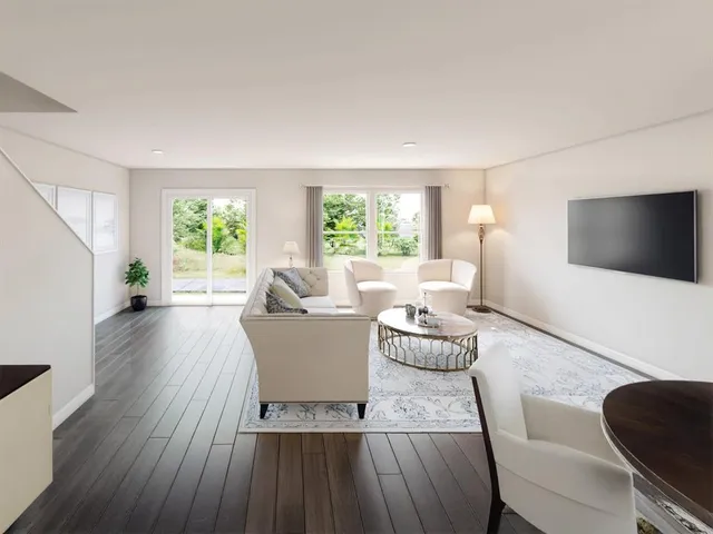 a living room with furniture a flat screen tv and a large window