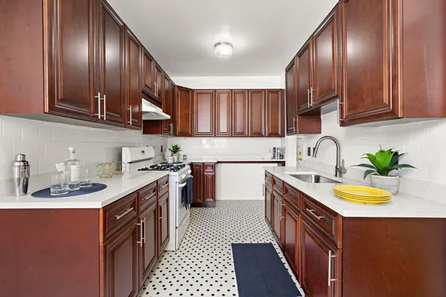 a kitchen with a sink a stove cabinets and a window