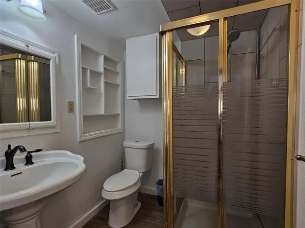 a bathroom with a toilet sink vanity and shower