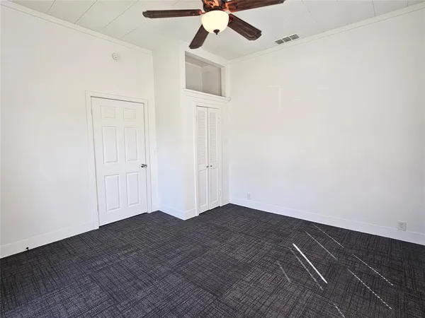 an empty room with a ceiling fan and wooden floor