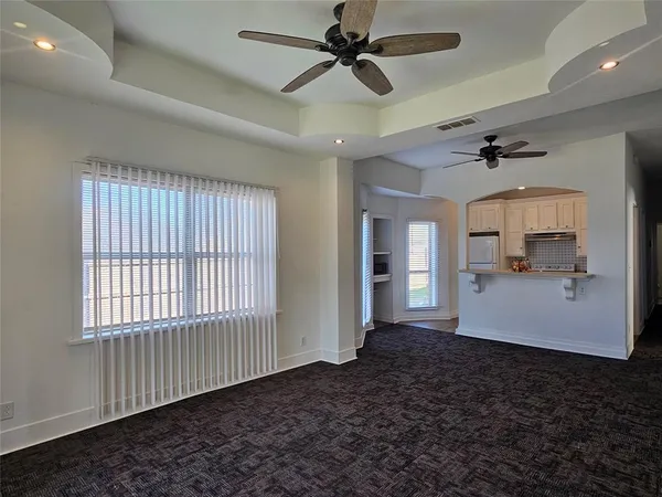 a view of a room with a ceiling fan and window