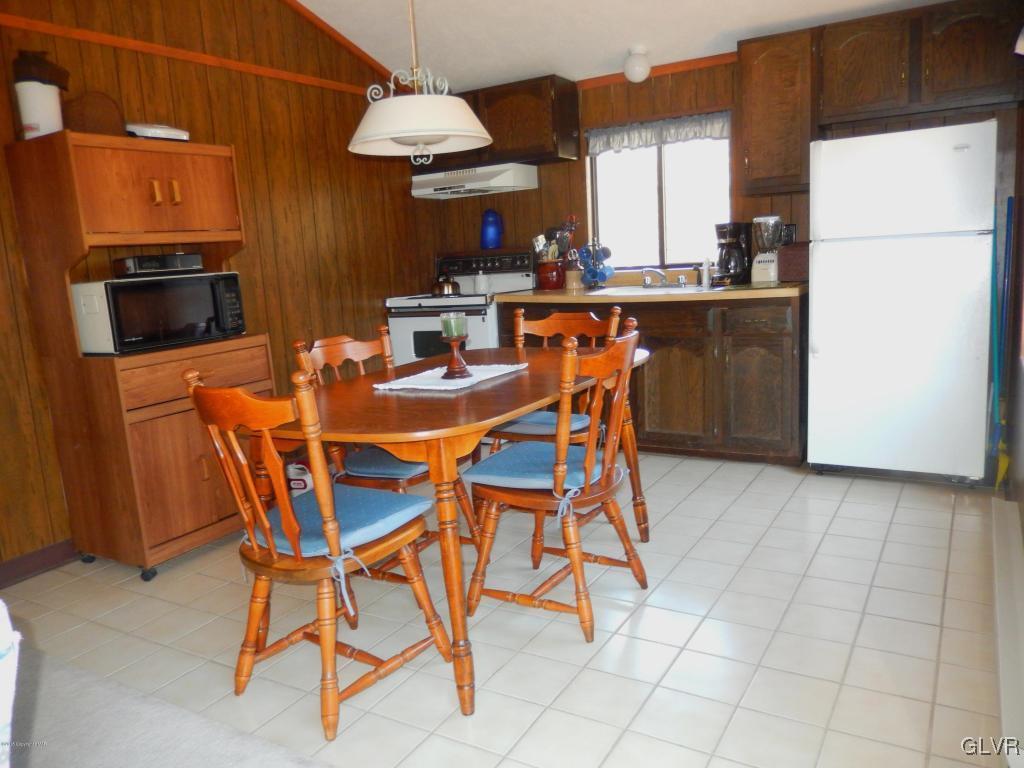 6122 Decker Road Bushkill, PA 18324 - Photo 7 of 33 a dining room with a table chairs and a refrigerator