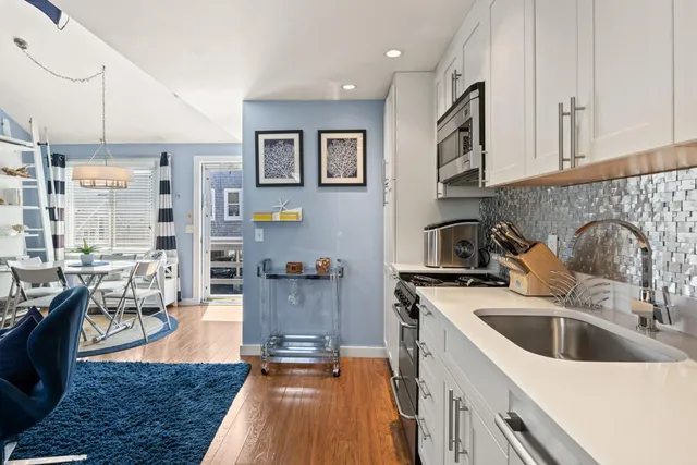 a kitchen with stainless steel appliances a sink a stove top oven a counter space and cabinets