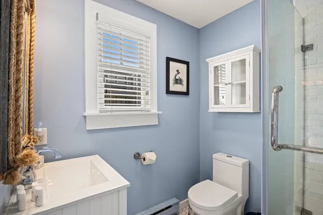 a bathroom with a sink a toilet and a window