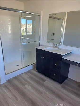 a view of a hallway to a livingroom with wooden floor and furniture