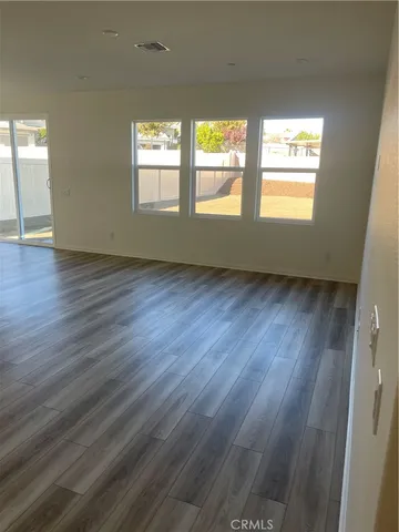 a view of a room with wooden floor and furniture