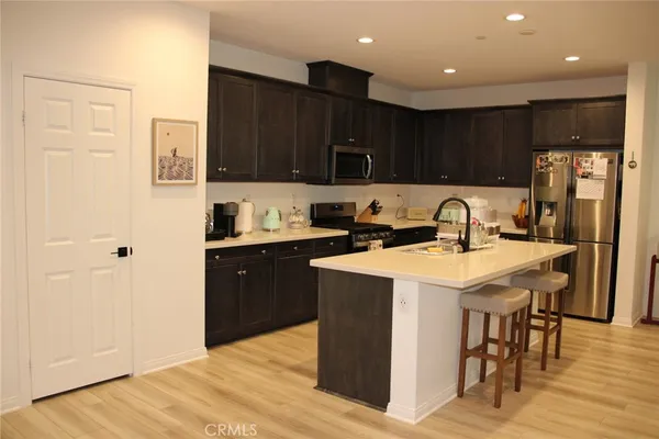 a kitchen with a sink a stove a refrigerator and cabinets
