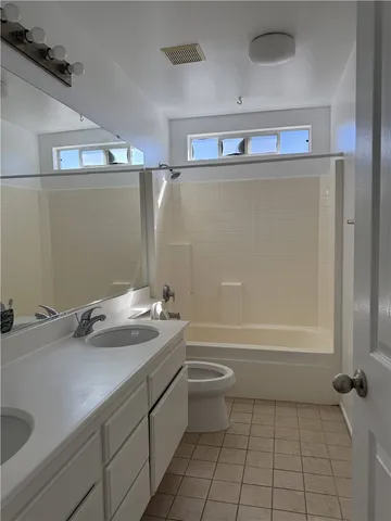 a bathroom with a granite countertop sink a toilet and bathtub