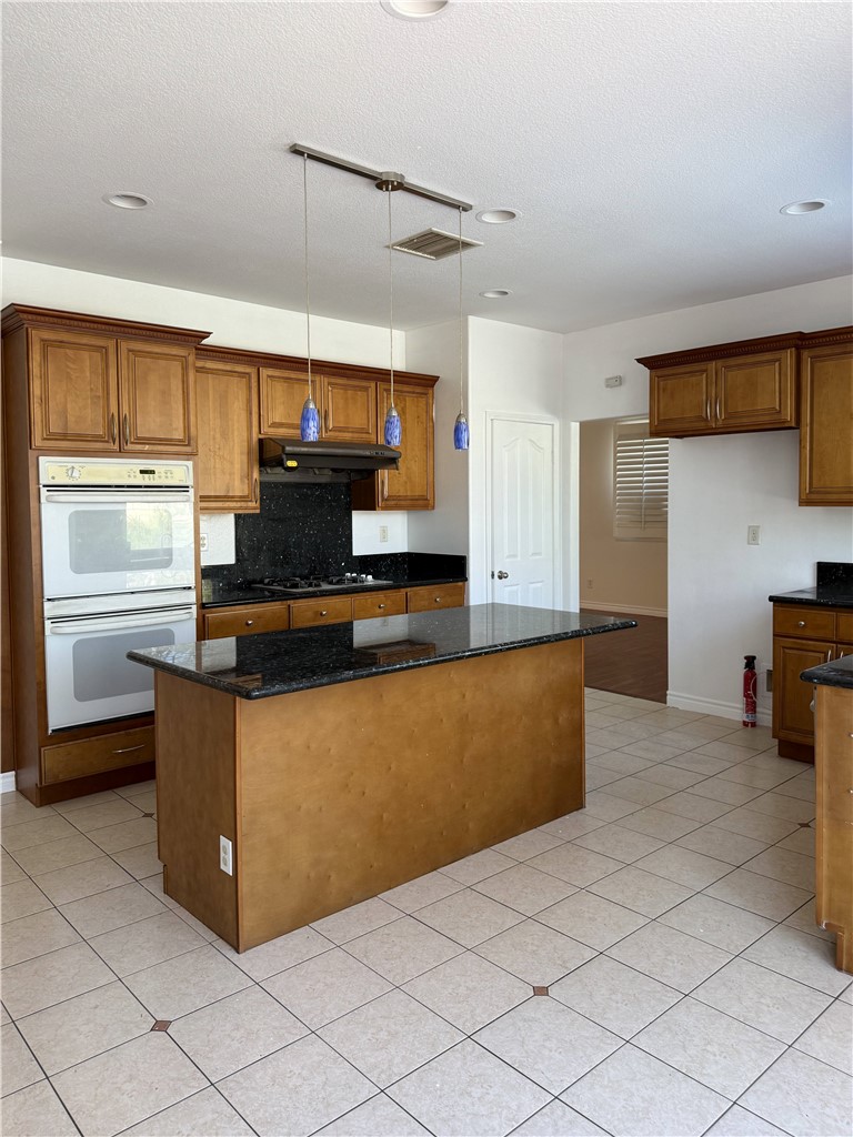 9593 Heartland Place Rancho Cucamonga, CA 91730 - Photo 3 of 13 a kitchen with stainless steel appliances granite countertop a refrigerator and a stove top oven