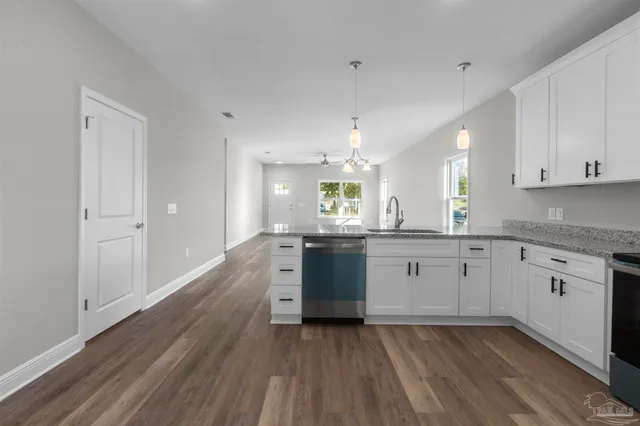 a kitchen with a refrigerator and white cabinets