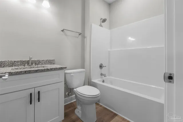 a bathroom with a granite countertop toilet a sink and a bathtub