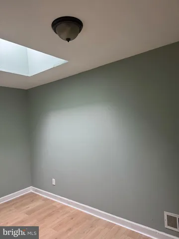 an empty room with a wooden floor and a window