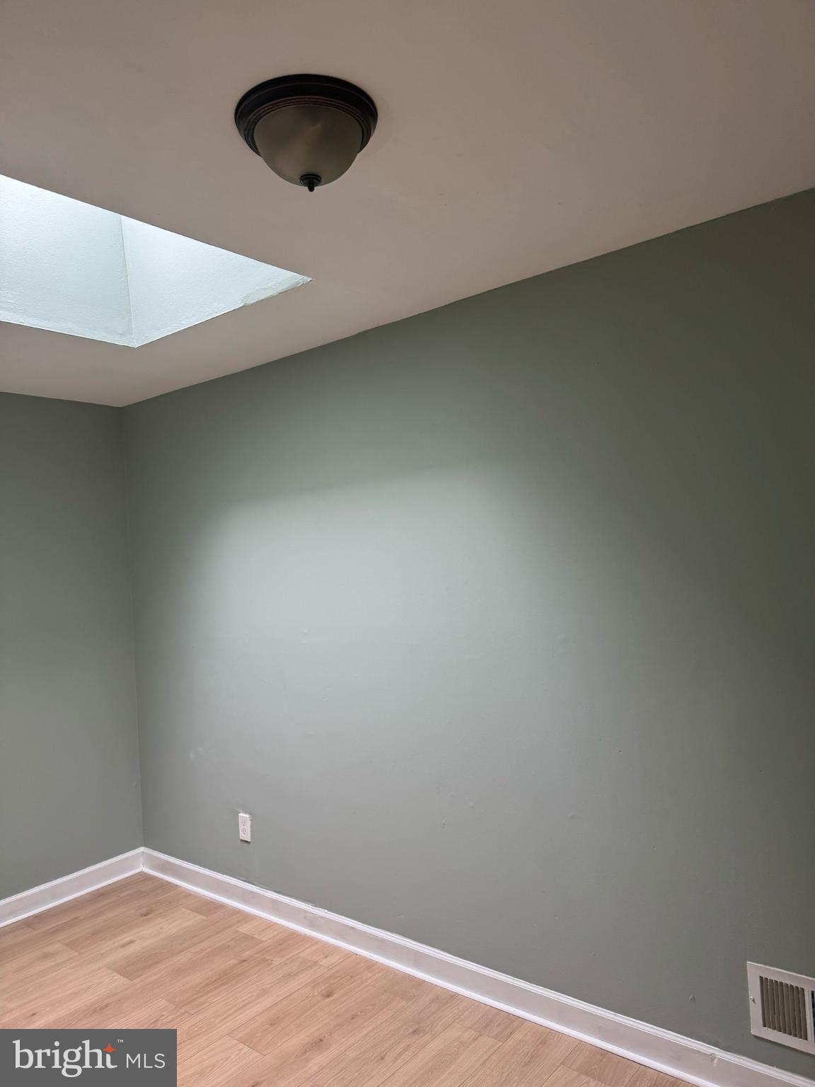 606 North Dukeland Street Baltimore, MD 21216 - Photo 8 of 11 an empty room with a wooden floor and a window