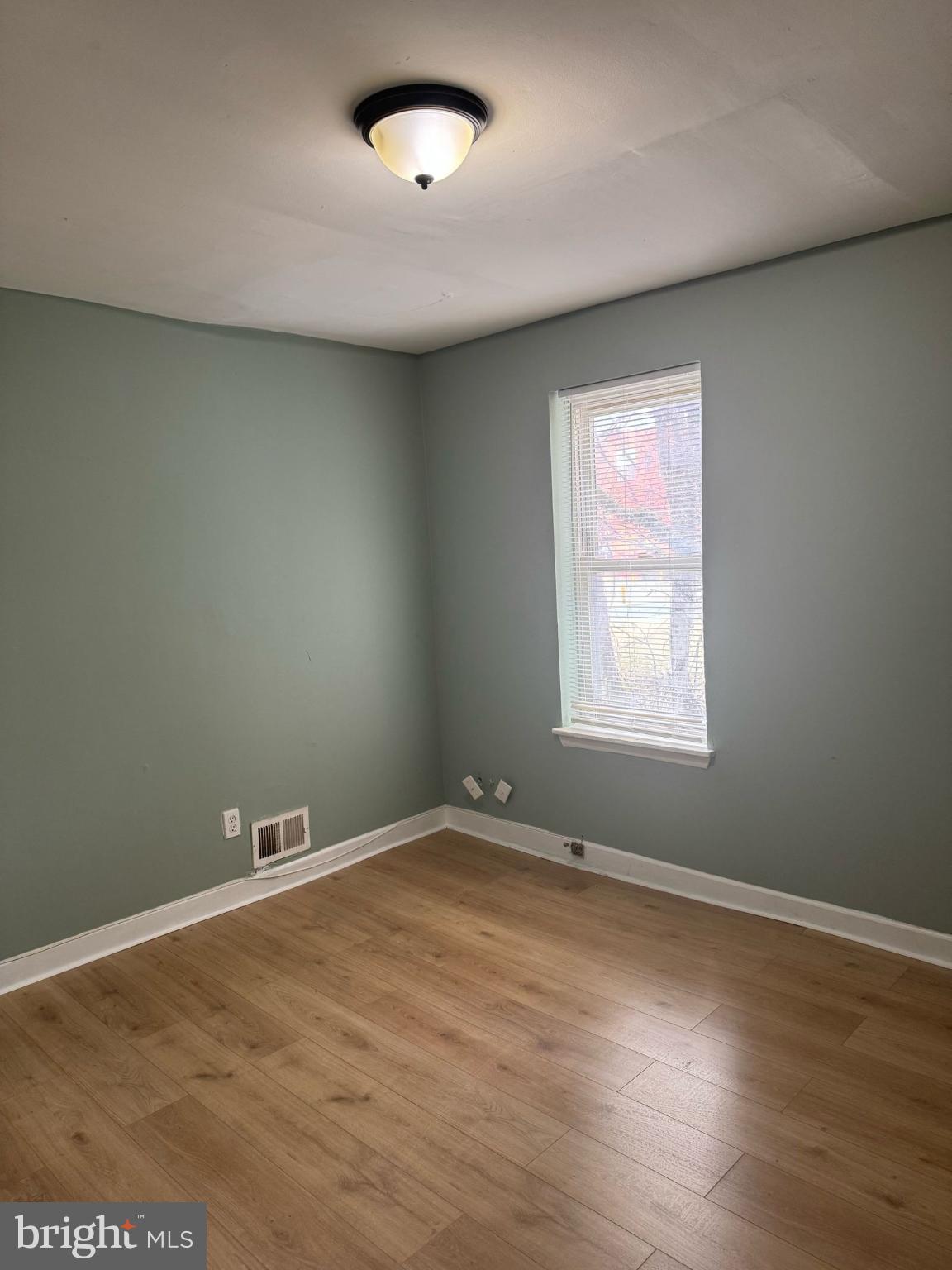 606 North Dukeland Street Baltimore, MD 21216 - Photo 9 of 11 an empty room with wooden floor and windows