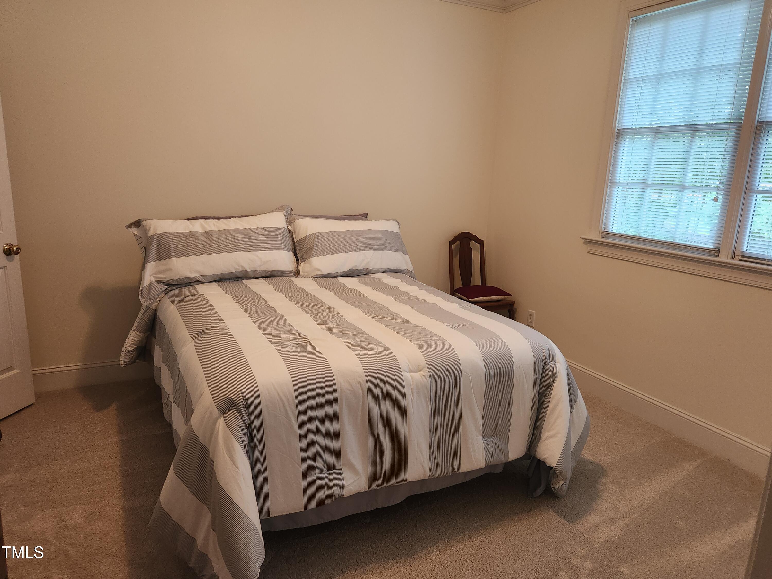 7516 Wingfoot Drive Raleigh, NC 27615 - Photo 22 of 34 a bedroom with a bed and window