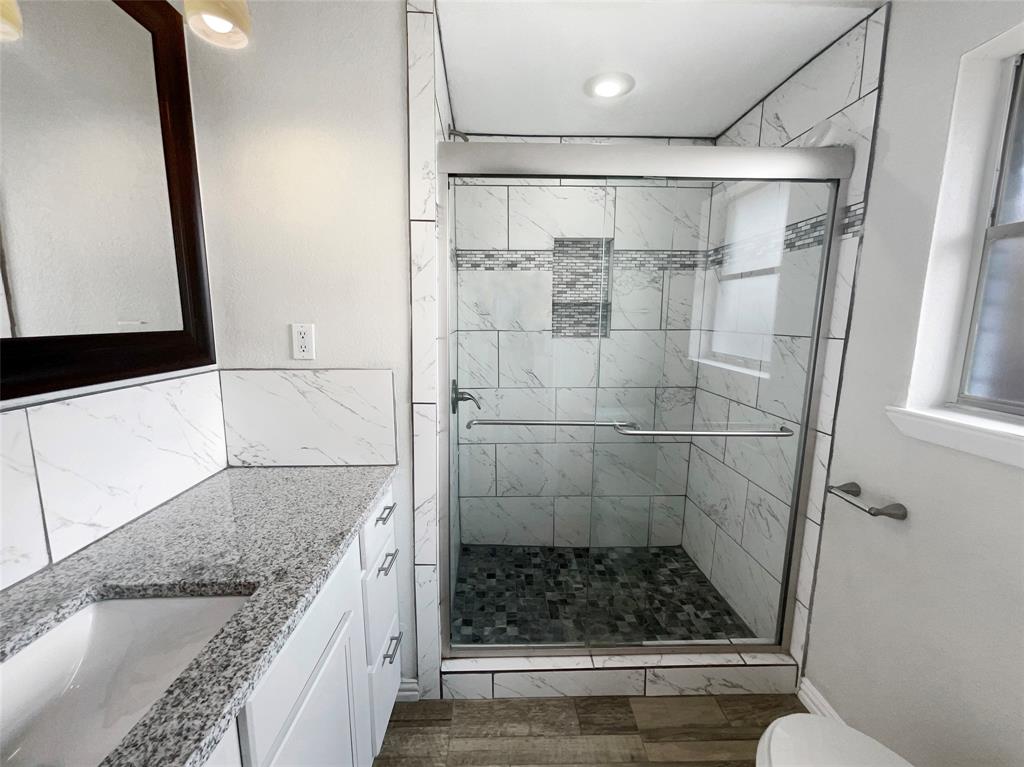 3925 Wedgworth Road South Fort Worth, TX 76133 - Photo 12 of 15 a bathroom with a granite countertop shower a sink and toilet