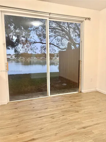 a view of a room with wooden floor and a floor to ceiling window