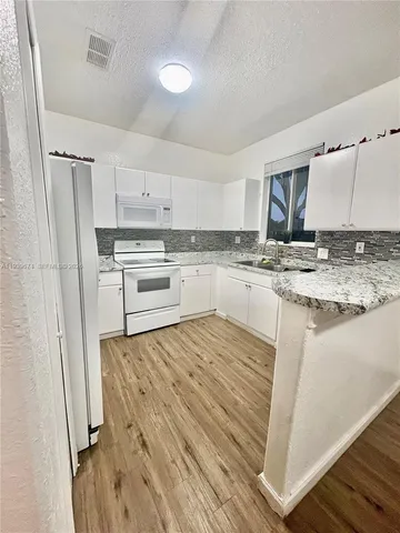 a kitchen with a sink stove and refrigerator