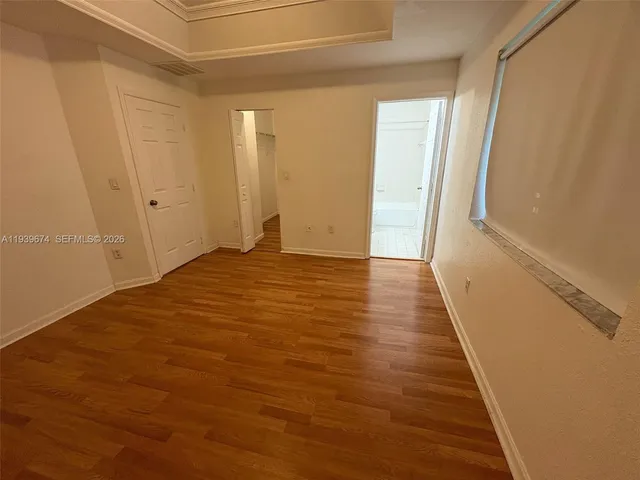 a view of an empty room with wooden floor