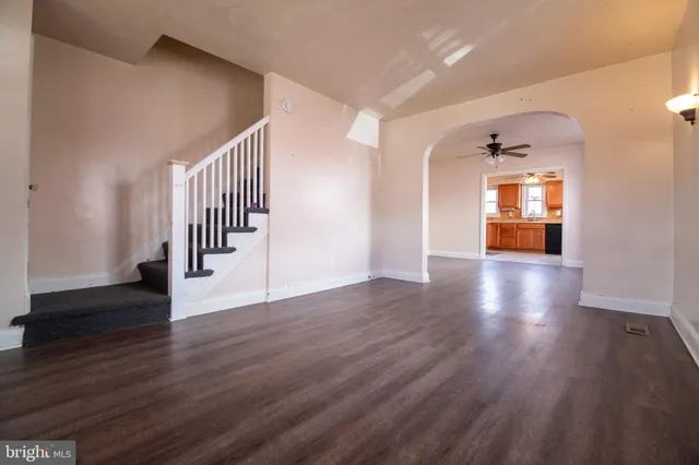 an empty room with wooden floor and stairs