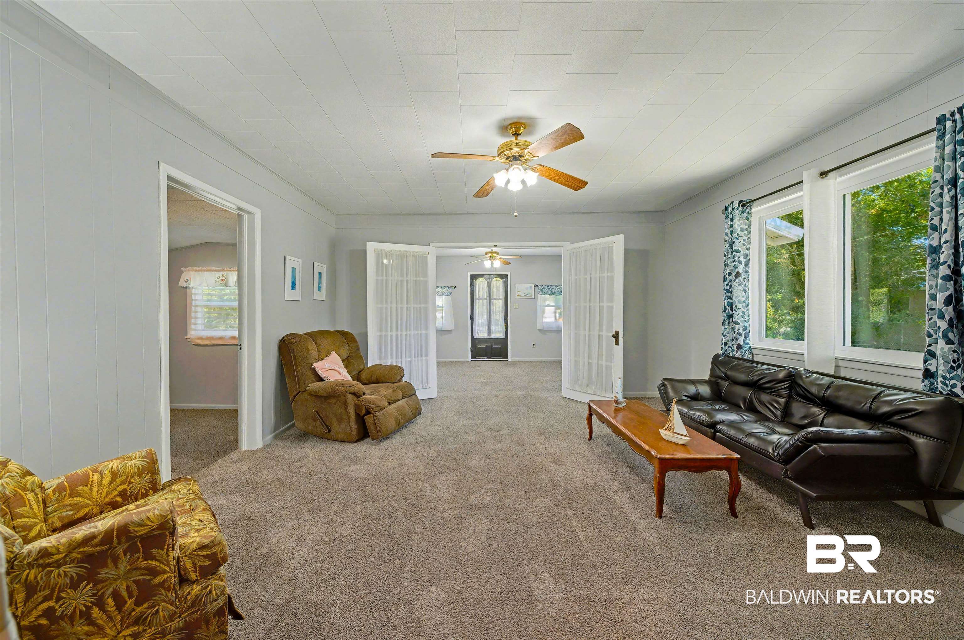 209 West Magnolia Avenue Foley, AL 36535 - Photo 10 of 23 Carpeted living area with a ceiling fan and french doors
