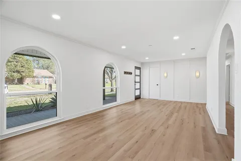 an empty room with window and wooden floor