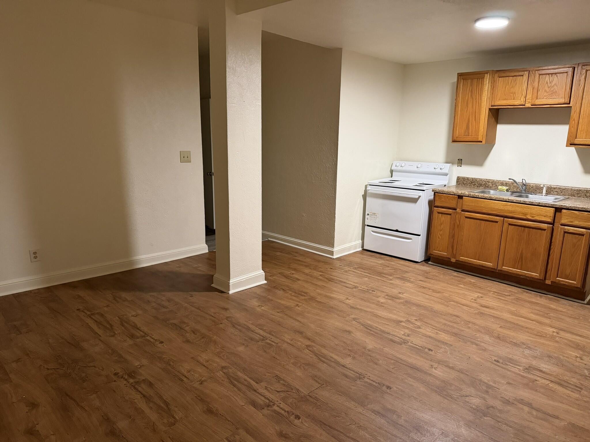 1209 Chapman Avenue Southwest, Unit B Roanoke, VA 24016 - Photo 4 of 7 a kitchen with granite countertop a stove cabinets and wooden floor