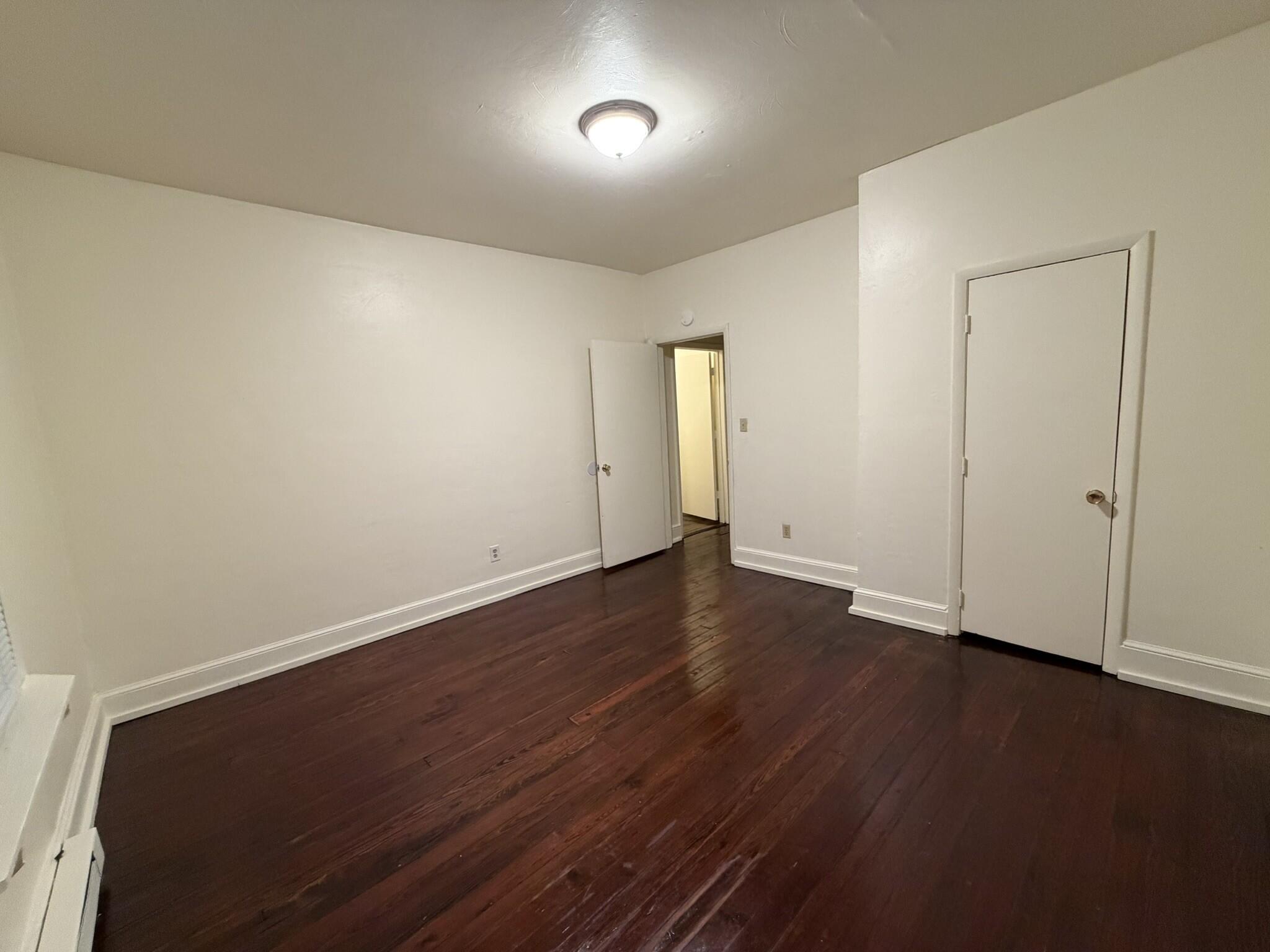 1209 Chapman Avenue Southwest, Unit B Roanoke, VA 24016 - Photo 6 of 7 an empty room with wooden floor and windows