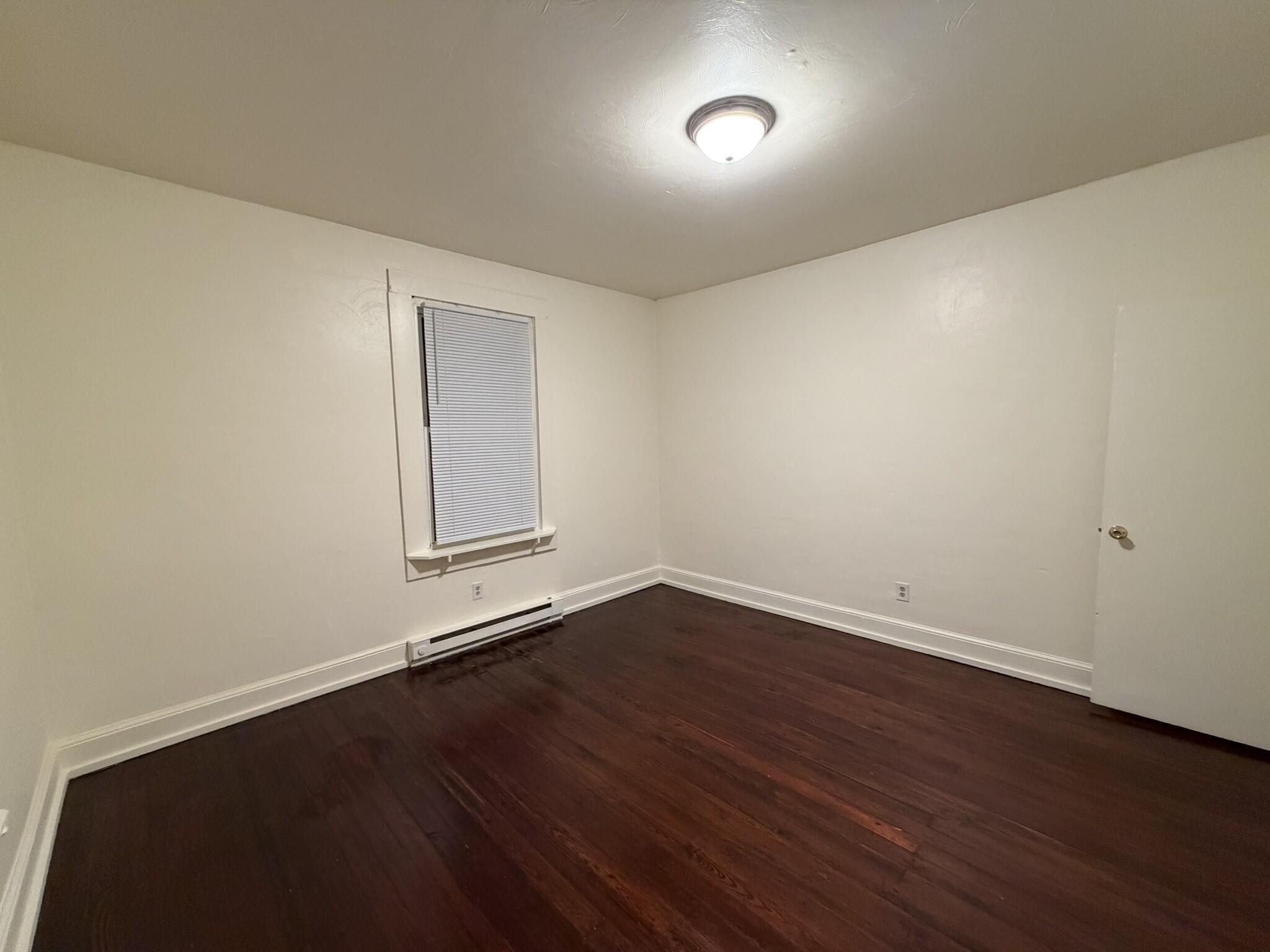 1209 Chapman Avenue Southwest, Unit B Roanoke, VA 24016 - Photo 7 of 7 an empty room with wooden floor and windows