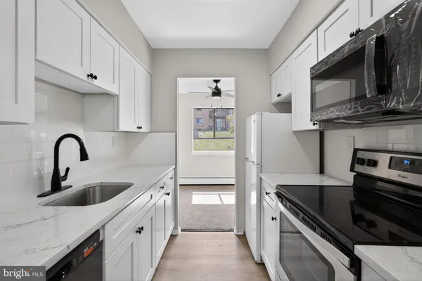 a kitchen with stainless steel appliances kitchen island a stove a sink and a microwave