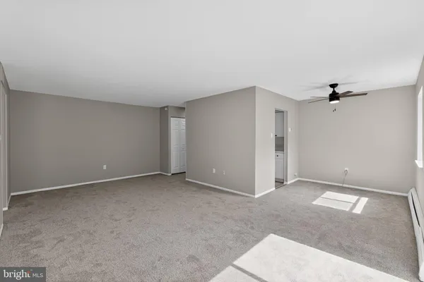 a view of a big room with windows and chandelier fan