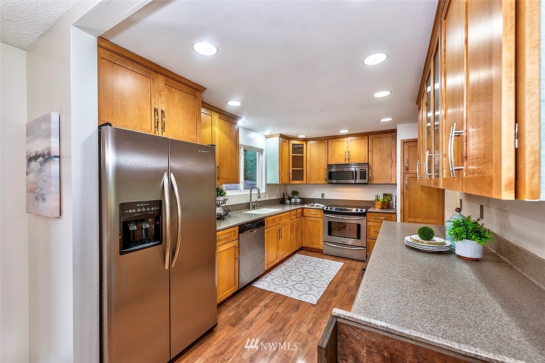 23002 Atlas Road Bothell, WA 98021 - Photo 8 of 23 a kitchen with stainless steel appliances granite countertop a refrigerator a stove and a sink