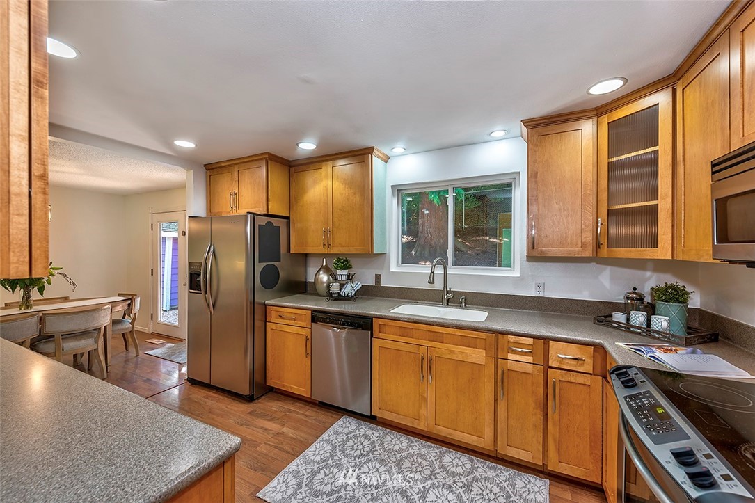23002 Atlas Road Bothell, WA 98021 - Photo 9 of 23 a kitchen with stainless steel appliances granite countertop a refrigerator a sink dishwasher stove and oven
