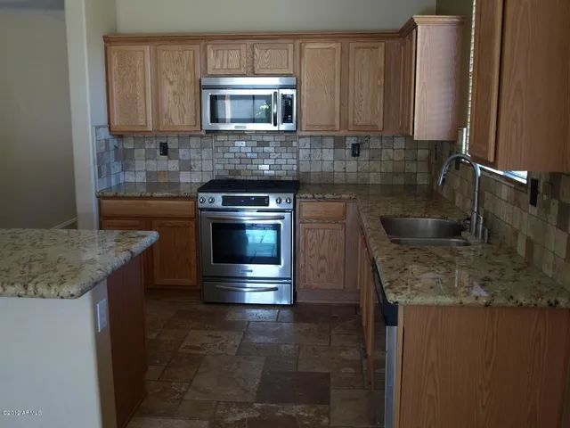 a kitchen with granite countertop a sink and a stove