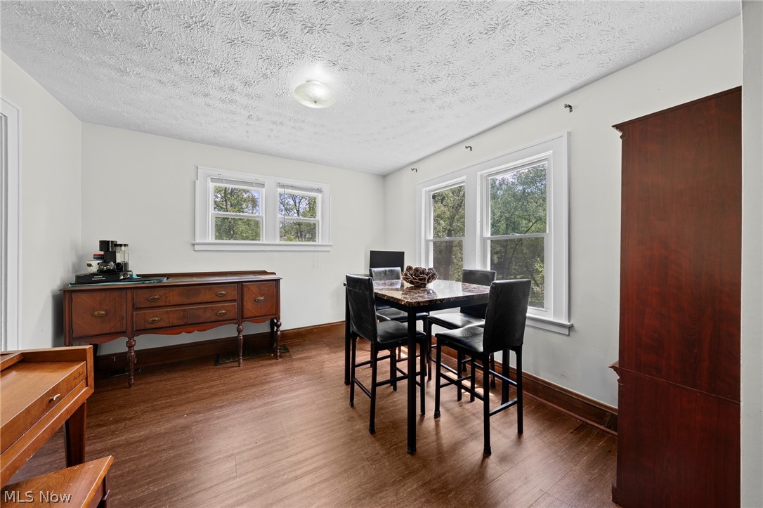 819 Keeney Street Akron, OH 44310 - Photo 10 of 24 Bright room featuring wood-finish flooring, multiple windows with white trim, and a textured ceiling