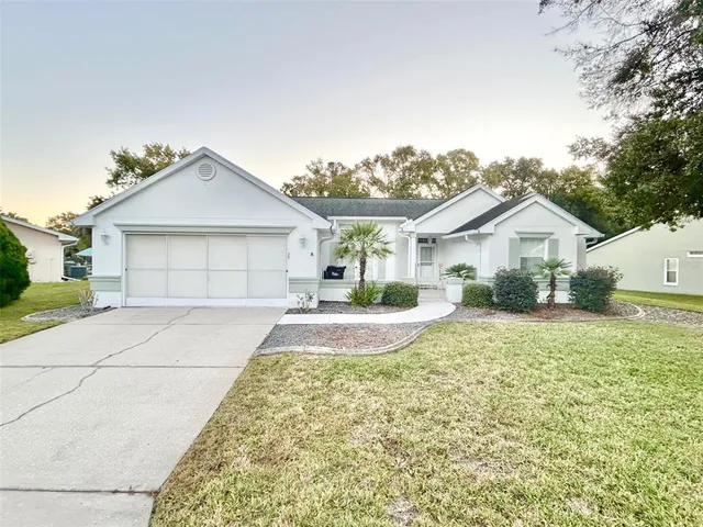a front door view of a house with a yard and garage