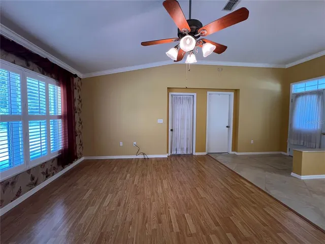 a view of an empty room with window and wooden floor